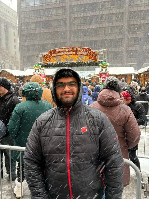 Karan smiling in the snow at Christkindlmarket Chicago